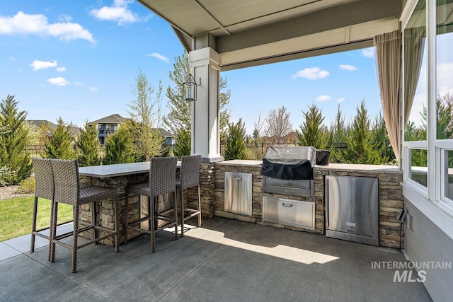 view of patio / terrace with an outdoor kitchen, an outdoor bar, and grilling area