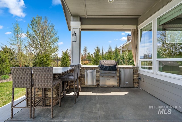 view of patio with an outdoor kitchen, an outdoor bar, and grilling area