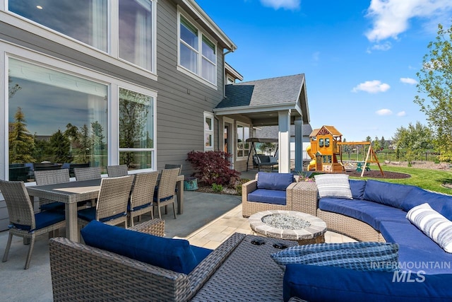 view of patio / terrace with a playground and an outdoor living space with a fire pit