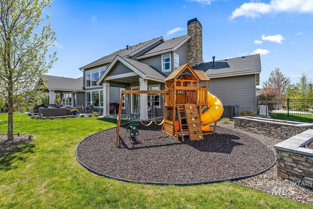 back of property featuring an outdoor living space, a playground, a patio area, and a lawn