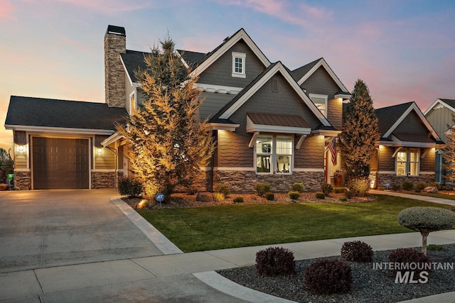 craftsman-style home featuring a garage and a lawn