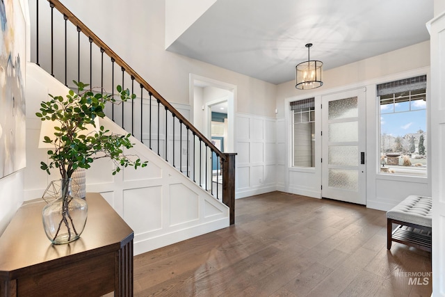 entrance foyer with dark hardwood / wood-style floors and a notable chandelier