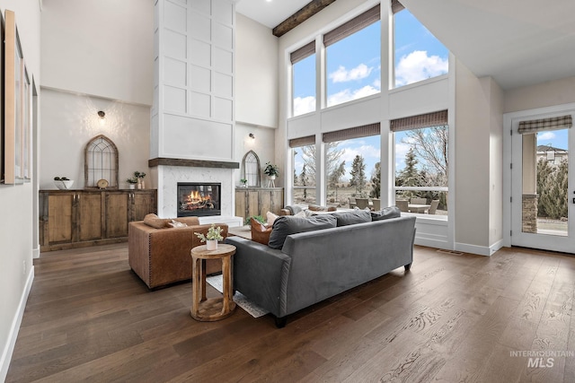living room with a wealth of natural light, dark wood-type flooring, and high vaulted ceiling