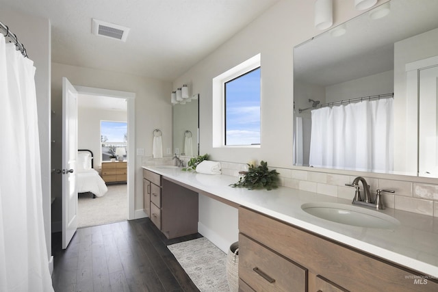 bathroom with wood-type flooring, vanity, and backsplash