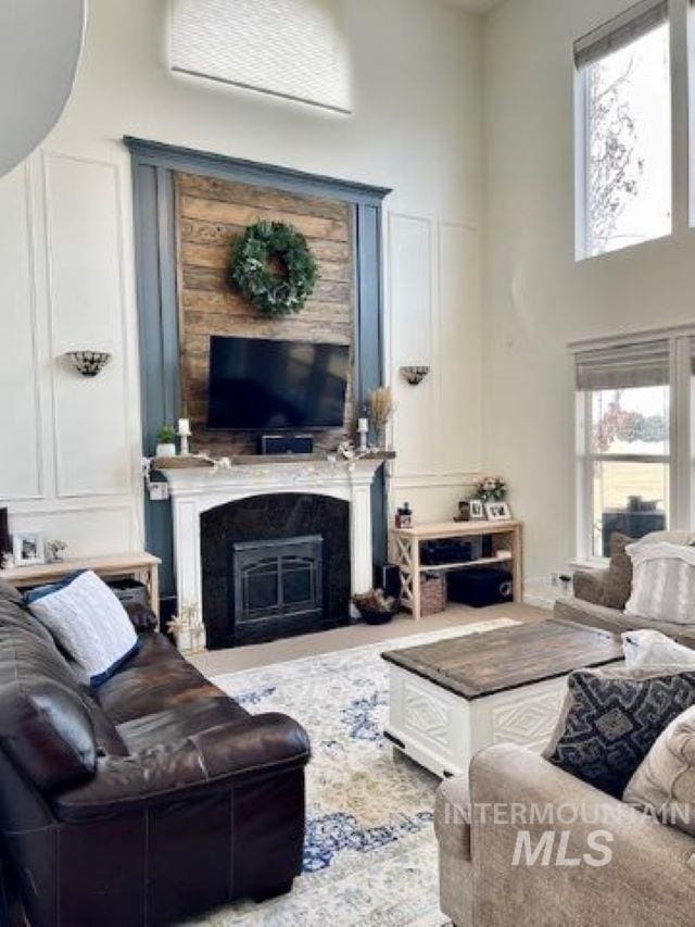 living area featuring a high ceiling and a fireplace with flush hearth