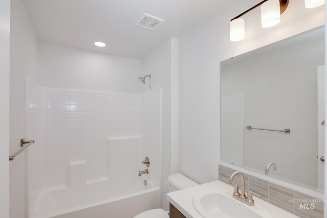 full bathroom featuring vanity, backsplash, bathing tub / shower combination, and toilet