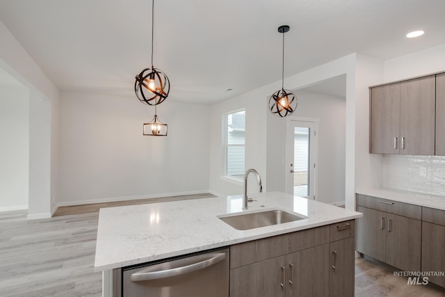 kitchen featuring a kitchen island with sink, sink, pendant lighting, light hardwood / wood-style flooring, and dishwasher