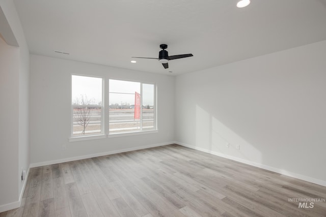 empty room with ceiling fan and light hardwood / wood-style flooring