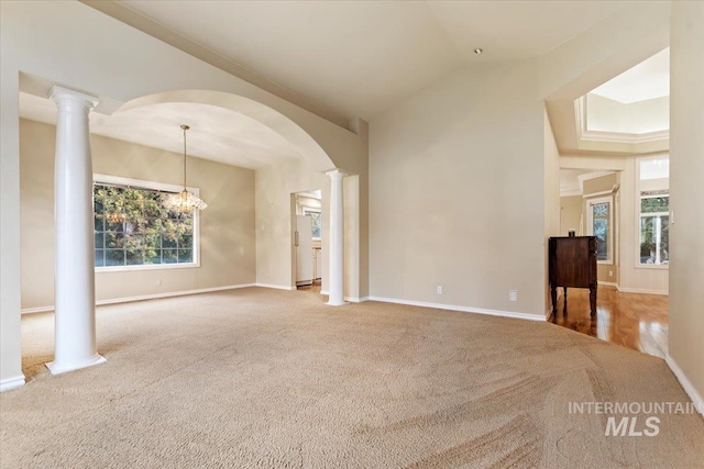 interior space with an inviting chandelier, decorative columns, and lofted ceiling