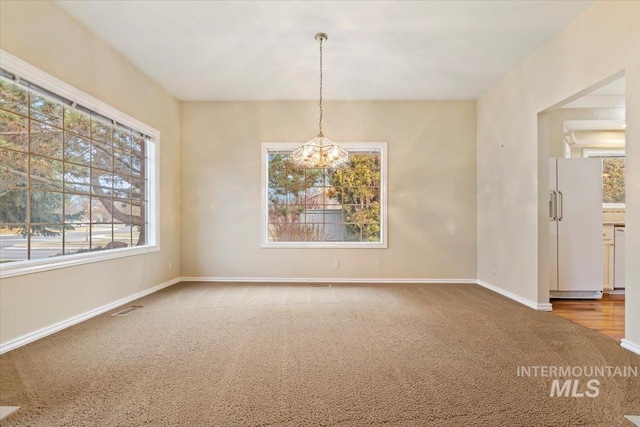 empty room with an inviting chandelier and carpet