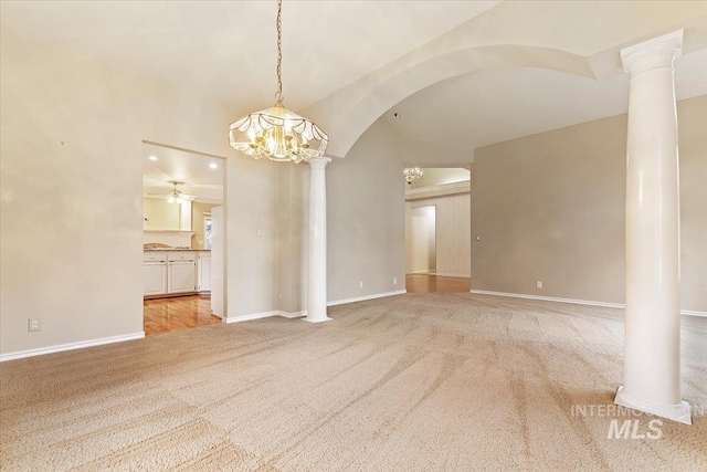 unfurnished living room with ceiling fan with notable chandelier and light colored carpet