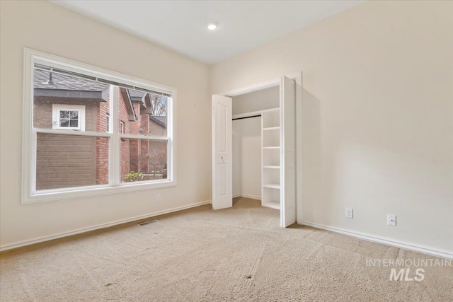 unfurnished bedroom with a closet and light carpet