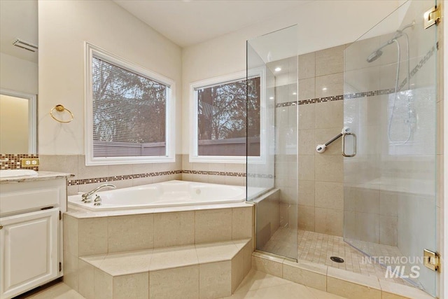 bathroom with tile patterned flooring, plus walk in shower, and vanity