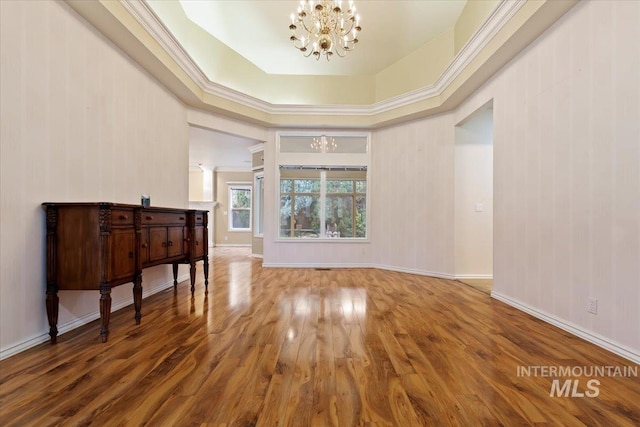 interior space featuring wood-type flooring, a chandelier, and a tray ceiling