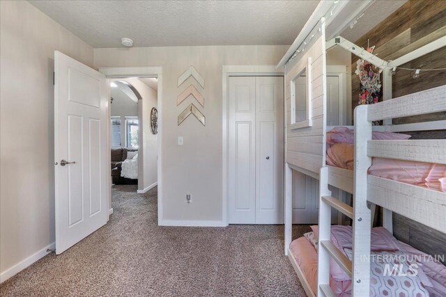 614 Ethan Ct, Jerome, ID 83338 - unfurnished bedroom featuring carpet floors, baseboards, arched walkways, and a closet
