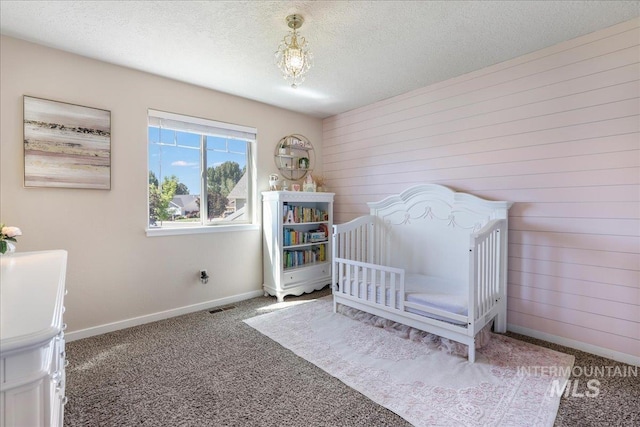 614 Ethan Ct, Jerome, ID 83338 - bedroom featuring carpet flooring, baseboards, wood walls, and a textured ceiling