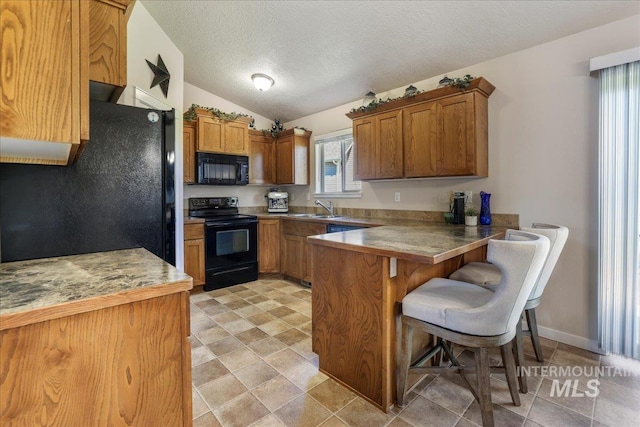 614 Ethan Ct, Jerome, ID 83338 - kitchen with black appliances, brown cabinetry, a peninsula, a textured ceiling, and a sink
