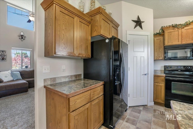 614 Ethan Ct, Jerome, ID 83338 - kitchen featuring black appliances, brown cabinetry, open floor plan, and a textured ceiling