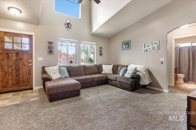 614 Ethan Ct, Jerome, ID 83338 - living room with ceiling fan, arched walkways, baseboards, a high ceiling, and carpet floors