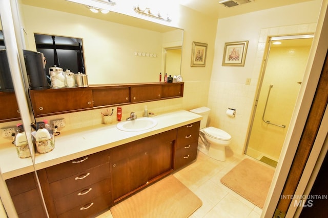 708 16th St, Clarkston, WA 99403 - bathroom with vanity, tile patterned flooring, tile walls, a shower stall, and a wainscoted wall