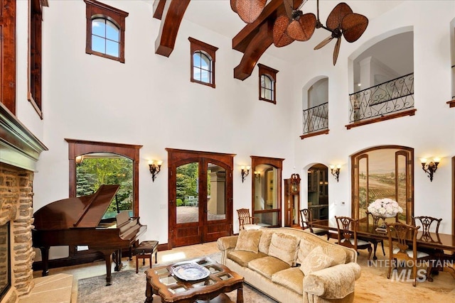 living room with french doors, ceiling fan, and a towering ceiling