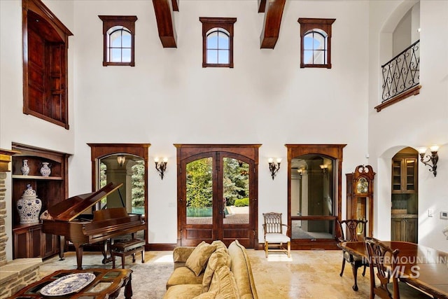 living room with french doors, a towering ceiling, and tile floors