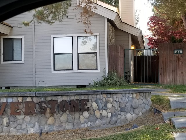 view of side of home featuring a chimney and fence