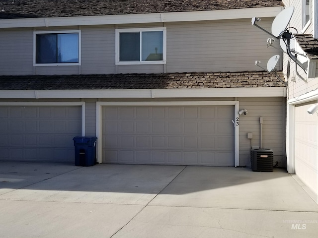 garage with concrete driveway and cooling unit