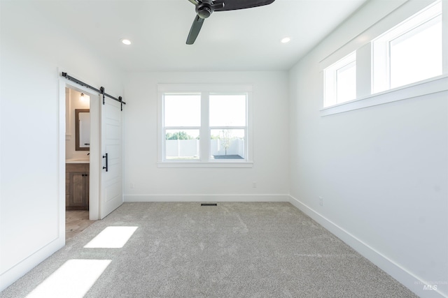 1246 E Rio Chico Dr, Kuna, ID 83634 - unfurnished bedroom featuring a barn door, multiple windows, carpet flooring, recessed lighting, and baseboards