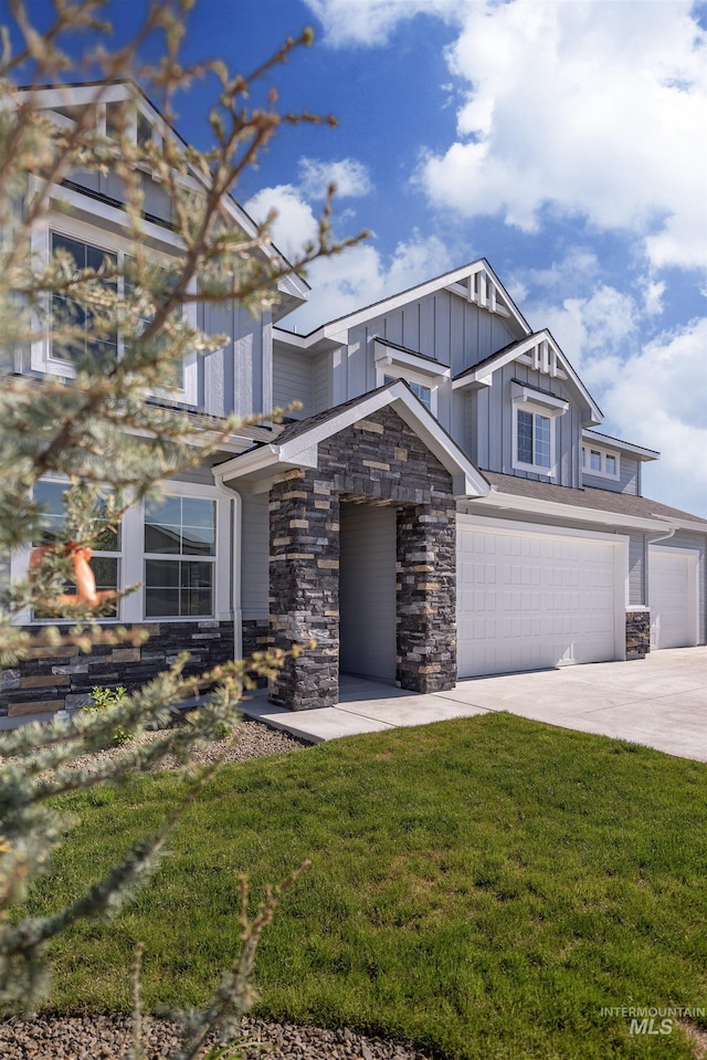 1246 E Rio Chico Dr, Kuna, ID 83634 - view of front of property featuring board and batten siding, stone siding, concrete driveway, a front yard, and an attached garage
