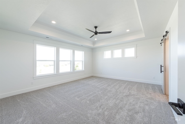 1246 E Rio Chico Dr, Kuna, ID 83634 - unfurnished room featuring a tray ceiling, recessed lighting, ceiling fan, a barn door, and baseboards