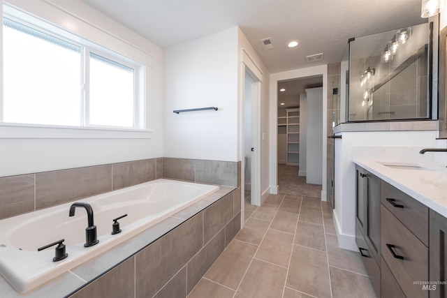 1246 E Rio Chico Dr, Kuna, ID 83634 - bathroom featuring vanity, a bath, a spacious closet, tile patterned floors, and recessed lighting