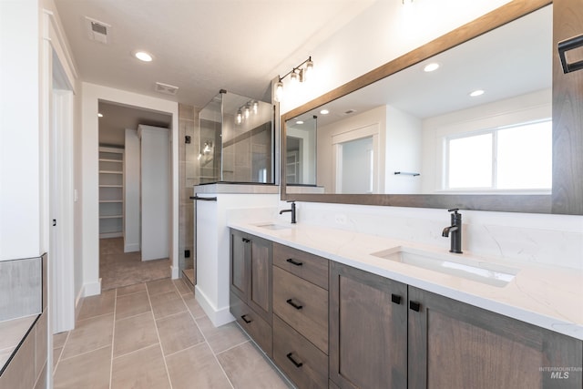 1246 E Rio Chico Dr, Kuna, ID 83634 - bathroom featuring double vanity, a stall shower, recessed lighting, a walk in closet, and tile patterned flooring