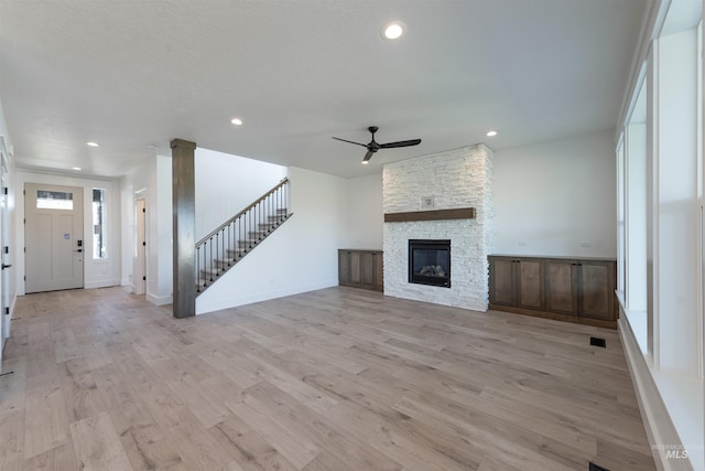 1246 E Rio Chico Dr, Kuna, ID 83634 - unfurnished living room with a ceiling fan, recessed lighting, stairs, light wood-type flooring, and a fireplace