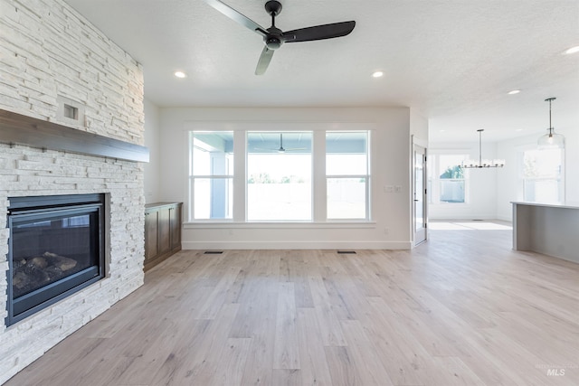 1246 E Rio Chico Dr, Kuna, ID 83634 - unfurnished living room with a ceiling fan, baseboards, light wood finished floors, a fireplace, and recessed lighting