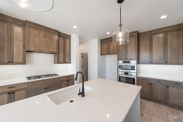 1246 E Rio Chico Dr, Kuna, ID 83634 - kitchen with a sink, stainless steel appliances, backsplash, light wood-type flooring, and recessed lighting