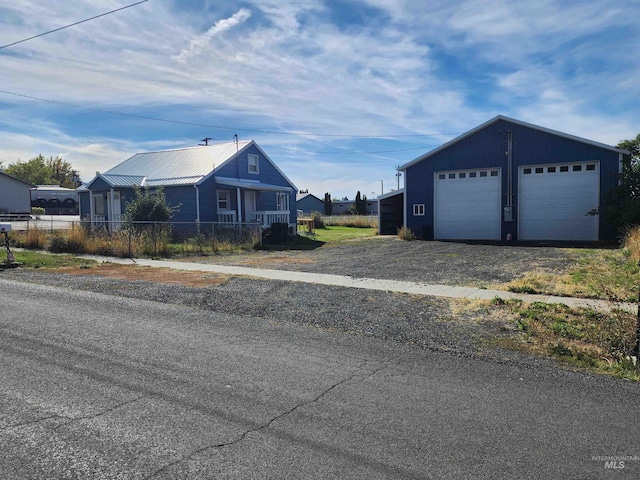 view of front of house featuring a garage and an outbuilding