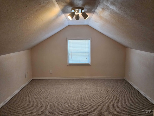 bonus room featuring lofted ceiling, a textured ceiling, and carpet flooring