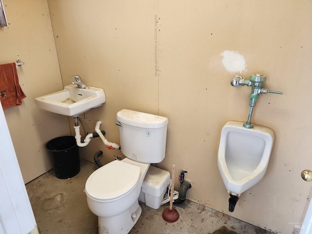 bathroom with toilet, concrete floors, and sink