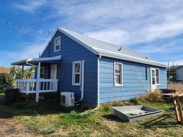 view of side of property with ac unit and a yard