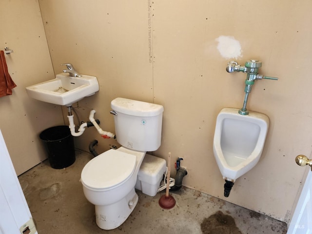 bathroom featuring toilet, concrete flooring, and sink