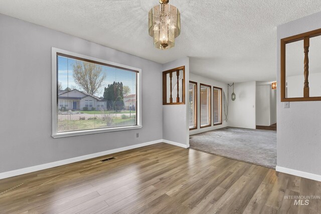 204 Hilldrop St, Caldwell, ID 83605 - unfurnished room featuring baseboards, wood finished floors, visible vents, and a textured ceiling
