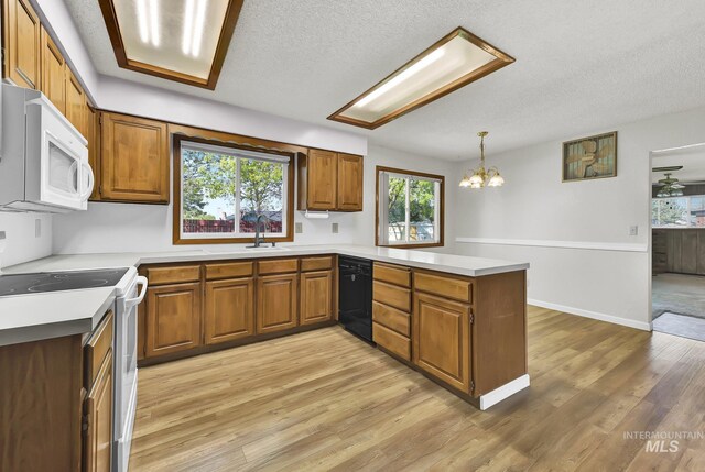 204 Hilldrop St, Caldwell, ID 83605 - kitchen featuring brown cabinetry, a peninsula, and white appliances