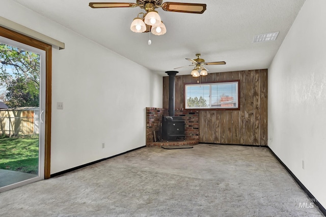 204 Hilldrop St, Caldwell, ID 83605 - unfurnished living room with visible vents, carpet floors, a wood stove, and a healthy amount of sunlight