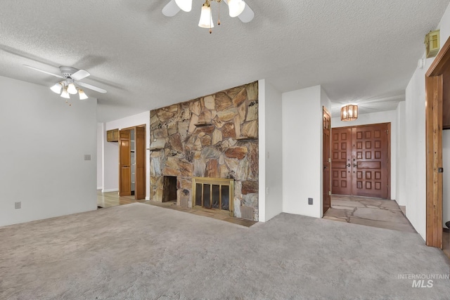 204 Hilldrop St, Caldwell, ID 83605 - unfurnished living room featuring a stone fireplace, a ceiling fan, a textured ceiling, and carpet