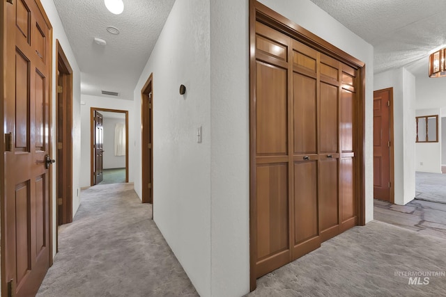204 Hilldrop St, Caldwell, ID 83605 - hallway with a textured ceiling, light colored carpet, and visible vents