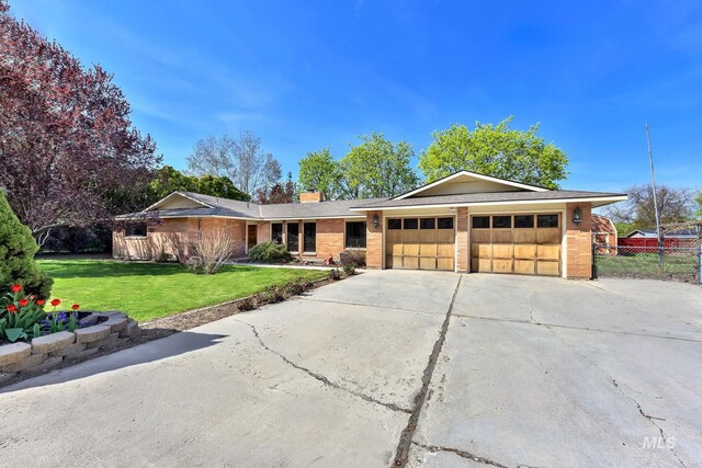 204 Hilldrop St, Caldwell, ID 83605 - ranch-style home featuring concrete driveway, an attached garage, fence, a front yard, and brick siding