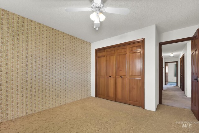 204 Hilldrop St, Caldwell, ID 83605 - unfurnished bedroom with wallpapered walls, a textured ceiling, carpet floors, and a closet