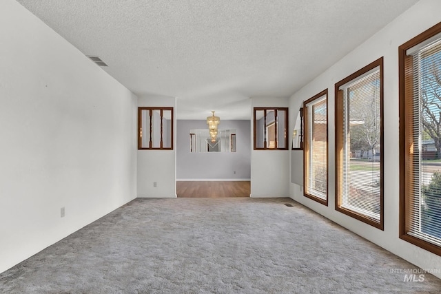 204 Hilldrop St, Caldwell, ID 83605 - carpeted spare room featuring a notable chandelier, a textured ceiling, and visible vents