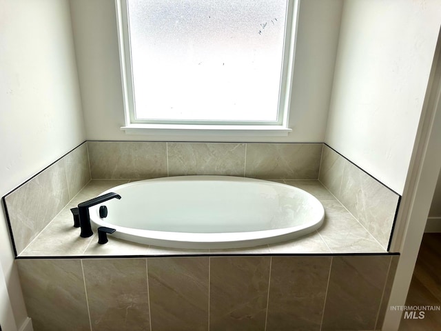 bathroom with plenty of natural light and a bath